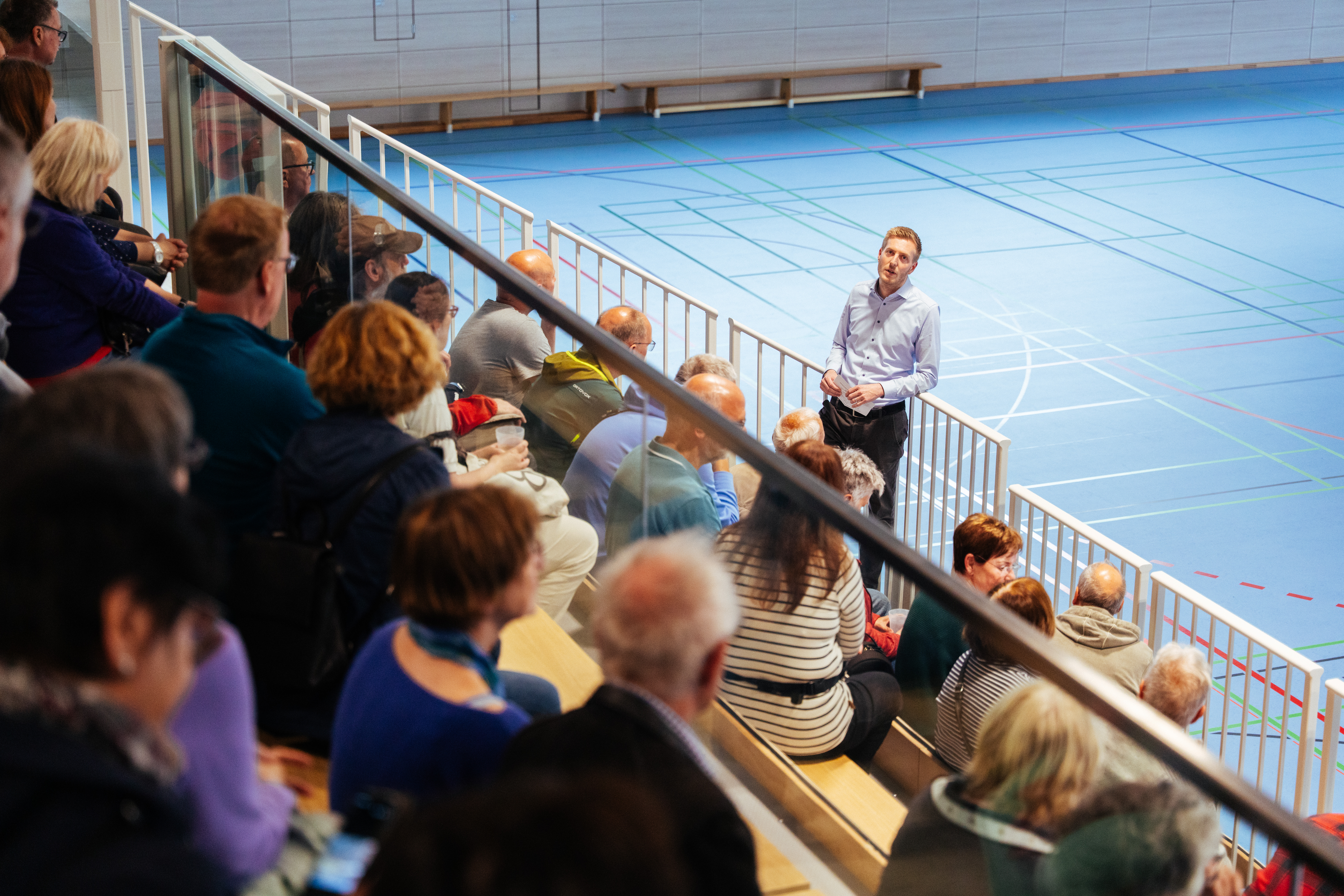 Lucas Risse spricht mit Bürgerinnen und Bürgern in der neuen Sporthalle